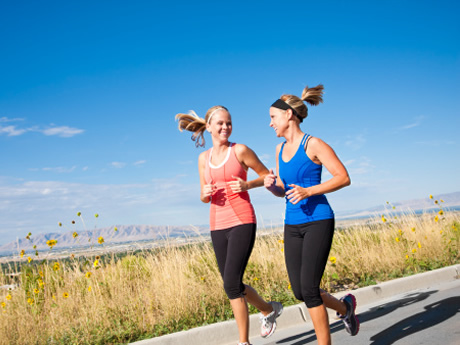 Two young woman jogging on the road